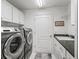 Well-appointed laundry room with washer, dryer, and utility sink at 1512 Shale Trail Loop, The Villages, FL 32163