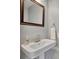 Small bathroom with pedestal sink, mirror, and white tile at 2000 N Westmoreland Dr, Orlando, FL 32804