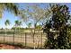 Landscaped backyard with a black metal fence and a view of a lake and golf course at 2825 Attwater Loop, Winter Haven, FL 33884