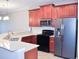 Modern kitchen featuring wood cabinets, stainless steel appliances, and a breakfast bar at 2825 Attwater Loop, Winter Haven, FL 33884