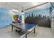 Fun game room with ping pong table, superhero mural, and NYC skyline art at 471 Lasso Dr, Kissimmee, FL 34747