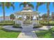 White gazebo with benches, surrounded by palm trees and landscaping at 471 Lasso Dr, Kissimmee, FL 34747