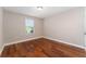 Bright bedroom with hardwood floors and neutral walls at 5905 Windsong Oak Dr, Leesburg, FL 34748