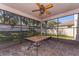 Relaxing screened porch with tiled floor and ceiling fan at 5905 Windsong Oak Dr, Leesburg, FL 34748