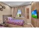 Well-lit bedroom featuring twin beds, window, and TV at 7598 Brooklyn Dr, Kissimmee, FL 34747