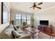 Spacious living room features a comfy sofa, large TV, and access to a balcony at 903 Charo Pkwy # 836, Davenport, FL 33897
