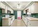 Galley kitchen with white appliances and green walls at 1755 Sunset Dr, Clermont, FL 34711