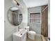 Updated bathroom with a round mirror, white vanity, and walk-in shower at 2410 Sanford Ave, Sanford, FL 32771