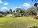 Landscaped front yard with a large green lawn and palm trees at 2410 Sanford Ave, Sanford, FL 32771