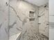 Large walk-in shower with marble tile and built-in shelving at 2410 Sanford Ave, Sanford, FL 32771