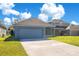 Attached garage with driveway and grassy area at 14643 Tanja King Blvd, Orlando, FL 32828
