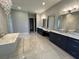 Luxurious bathroom with double vanities, a large soaking tub, and elegant tile work at 17144 Phil C Peters Rd, Winter Garden, FL 34787