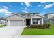 Two-story house with gray siding, stone accents, and a two-car garage at 4067 Meandering Bay Dr, Apopka, FL 32712