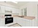 Galley kitchen with white cabinets and appliances at 8057 Laso Way, Orlando, FL 32822