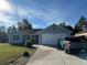 Cute blue house with a two-car garage and a nicely landscaped lawn at 8524 Se 160Th Pl, Summerfield, FL 34491