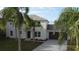 Two-story house with gray siding, brown garage door, and palm trees at 1115 Munster Ct, Kissimmee, FL 34759