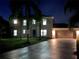 Two-story house with lit windows at night, brown garage door, and palm trees at 1115 Munster Ct, Kissimmee, FL 34759