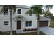 Two-story house with gray siding, brown garage door, and palm trees at 1115 Munster Ct, Kissimmee, FL 34759