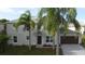 Two-story house with gray siding, brown garage door, and palm trees at 1115 Munster Ct, Kissimmee, FL 34759