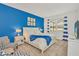 Spacious bedroom with white bed frame and blue blanket, featuring blue accent wall and window at 4481 Monado Dr, Kissimmee, FL 34746