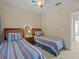 Two twin beds in a sunny bedroom with blue striped bedding and a ceiling fan at 8336 Riverdale Ln, Davenport, FL 33896