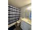 Updated bathroom with white vanity and blue shower curtain at 1023 S Hiawassee Rd # 4022, Orlando, FL 32835