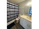 Updated bathroom with white vanity and blue shower curtain at 1023 S Hiawassee Rd # 4022, Orlando, FL 32835