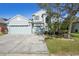 Two-story house with light blue exterior, two-car garage, and partially visible landscaping at 17835 Olive Oak Way, Orlando, FL 32820