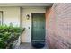 Inviting green front door entryway, brick accents, and lush landscaping at 261 S Wilderness Pt, Casselberry, FL 32707