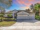 Stunning home exterior at sunset, featuring a three-car garage at 30325 Gidran Ter, Mount Dora, FL 32757