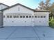 Three-car garage with white doors and two-toned exterior at 30325 Gidran Ter, Mount Dora, FL 32757