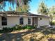 Tan house with red door, landscaping, and driveway at 304 N Lakeview Dr, Longwood, FL 32750