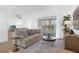 Living room featuring a beige couch, round coffee table, and large window at 448 Morning Creek Cir, Apopka, FL 32712