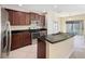 Kitchen with dark wood cabinets, stainless steel appliances, and an island at 4718 Rockvale Dr, Kissimmee, FL 34758
