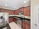 Kitchen with dark wood cabinets, granite counters, and stainless steel appliances at 4718 Rockvale Dr, Kissimmee, FL 34758