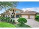 Two-story house with tile roof, three-car garage, and a brick paved driveway at 6245 Little Lake Sawyer Dr, Windermere, FL 34786