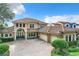 Two-story house with tile roof, three-car garage, and a brick paved driveway at 6245 Little Lake Sawyer Dr, Windermere, FL 34786