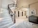 Large marble staircase with a metal railing and views to the living and dining areas at 6245 Little Lake Sawyer Dr, Windermere, FL 34786
