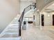 Large marble staircase with a metal railing and views to the living and dining areas at 6245 Little Lake Sawyer Dr, Windermere, FL 34786