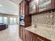 Wet bar with granite countertop and glass-front cabinetry at 6245 Little Lake Sawyer Dr, Windermere, FL 34786