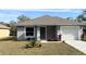 Newly constructed home with gray siding, attached garage, and landscaping at 6929 Central Ave, Mulberry, FL 33860