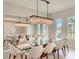 Bright dining room with glass table, white chairs, and chandelier at 8192 Ludington Cir, Orlando, FL 32836