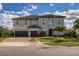 Two-story house with gray exterior, brown garage doors, and landscaping at 8192 Ludington Cir, Orlando, FL 32836
