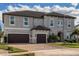 Two-story house with gray exterior, brown garage doors, and landscaping at 8192 Ludington Cir, Orlando, FL 32836