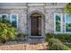 Elegant entryway with arched door, stone facade, and landscaping at 8192 Ludington Cir, Orlando, FL 32836