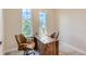 Home office with wood desk, two chairs, and large windows at 8192 Ludington Cir, Orlando, FL 32836