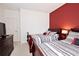 Bedroom with two twin beds and red accent wall at 8953 Shine Dr, Kissimmee, FL 34747