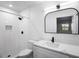 Modern bathroom with white tile, floating vanity, and arched mirror at 1621 Puritan,, Winter Park, FL 32792