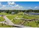 Aerial view of a park with walking trails, a lake, and lush greenery at 1724 Blue Lagoon Cir, Mascotte, FL 34753