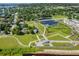 Aerial view showing a community with a park, lake, and residential areas at 1724 Blue Lagoon Cir, Mascotte, FL 34753